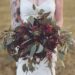 woman in white floral lace wedding dress holding red and green plant